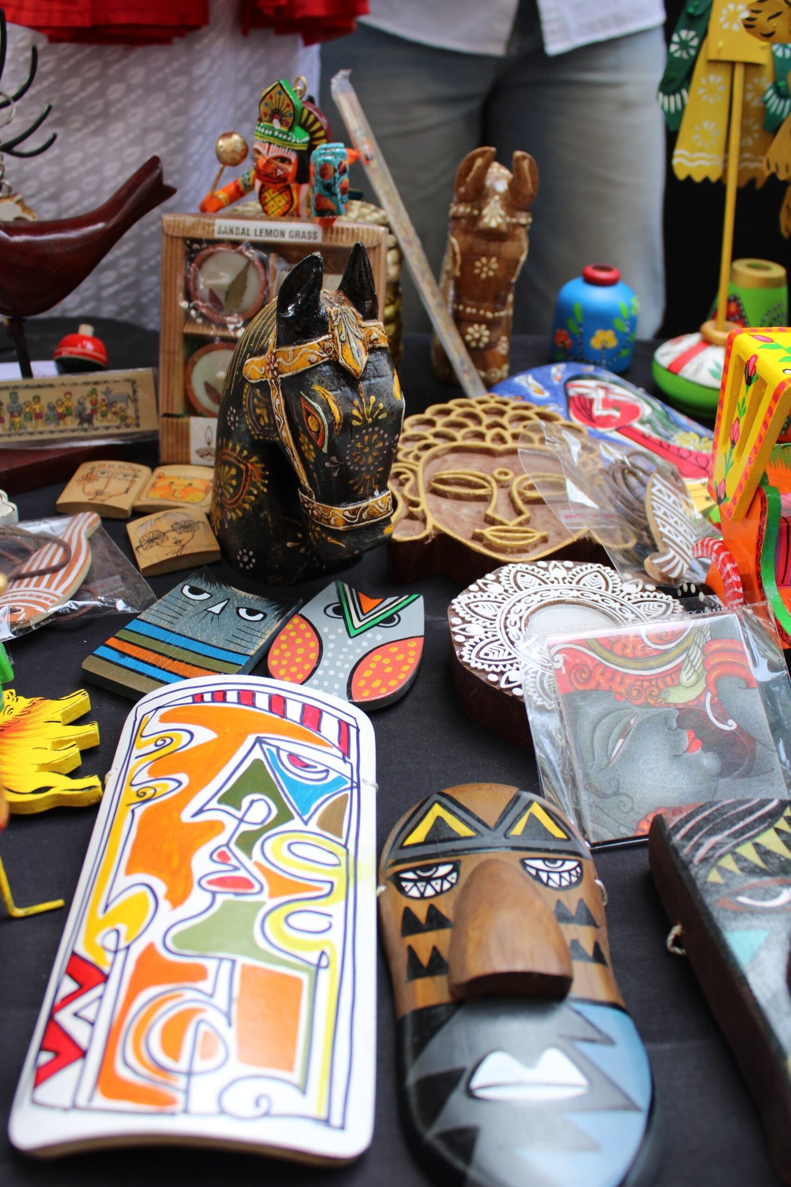 Close-up of a wooden horse, Buddha face, and handcrafted masks